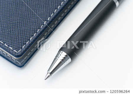 Close-up of a navy blue notebook and ballpoint pen Close-up of a navy blue notebook and ballpoint pen 120596264