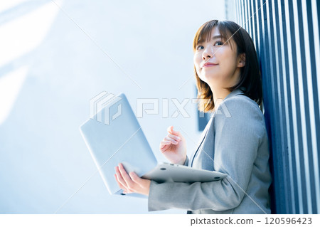 A woman in a suit using a computer, an office lady checking data 120596423