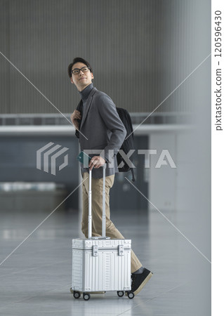 A man in his 40s walking with a carry bag 120596430