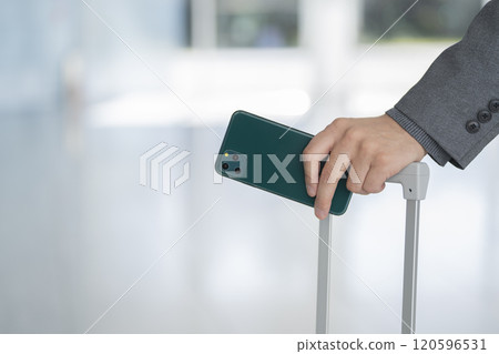Suitcase handle and man's hand holding smartphone Suitcase handle and man's hand holding smartphone 120596531
