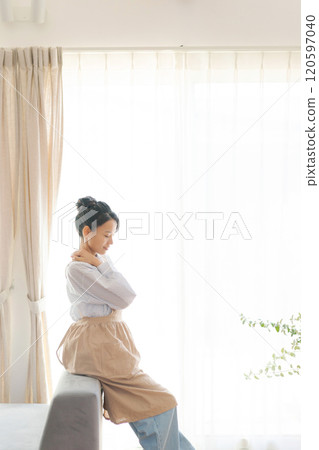 客廳窗邊站著一個穿著圍裙的女人 客廳窗邊站著一個穿著圍裙的女人 120597040
