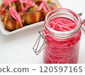 Pickled ginger in a storage jar and takoyaki on a plate 120597165