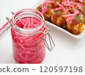 Pickled ginger in a storage jar and takoyaki on a plate 120597198
