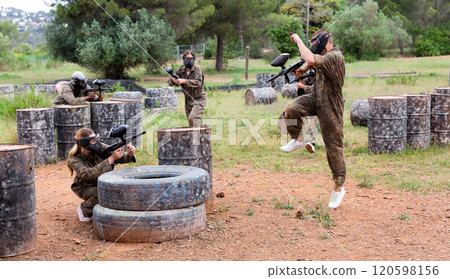 Two active opposing teams with guns playing paintball Two active opposing teams with guns playing paintball 120598156