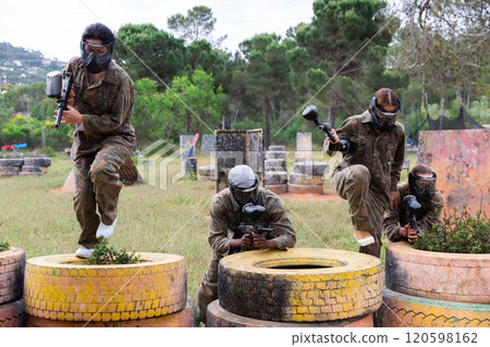 Two active opposing teams with guns playing paintball 120598162