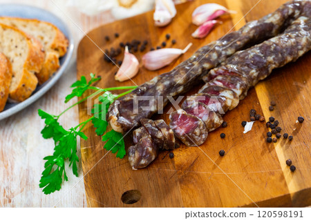 Dry pork sausage with condiments on table Dry pork sausage with condiments on table 120598191