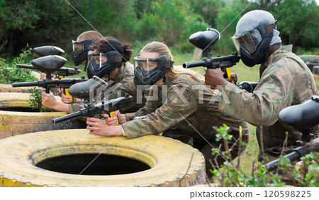 Group of people in full gear playing paintball on shooting range outdoor 120598225