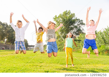Group of children jumping together on green grass Group of children jumping together on green grass 120598250