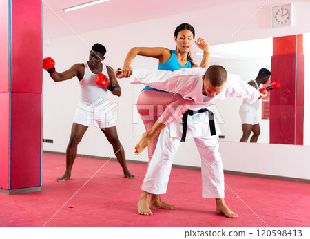 Asian female is fighting with trainer on the self-defense course for woman in sport gym 120598413