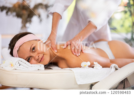 Young woman getting back and shoulder massage 120598483