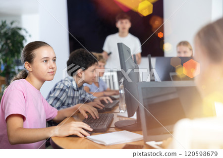 Preteen girl working with computer programs in training room Preteen girl working with computer programs in training room 120598679