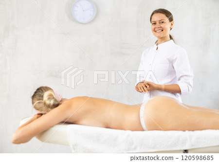Female physiotherapist poses against background of spa salons office. 120598685