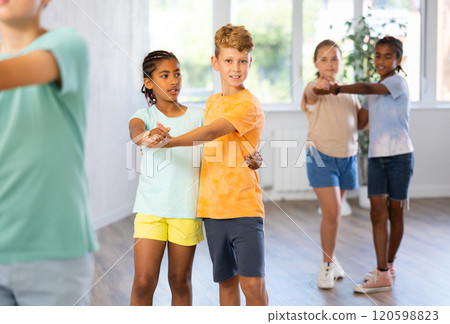 Light-skinned boy and African girlie learn figures of pair jive dance and train before competition Light-skinned boy and African girlie learn figures of pair jive dance and train before competition 120598823