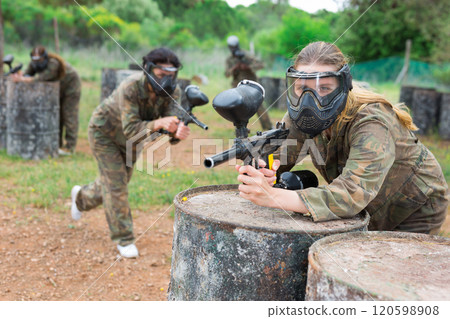 Portrait of girl in camouflage on paintball field 120598908