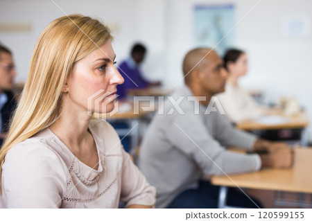 Adult woman studying with colleagues at classroom Adult woman studying with colleagues at classroom 120599155