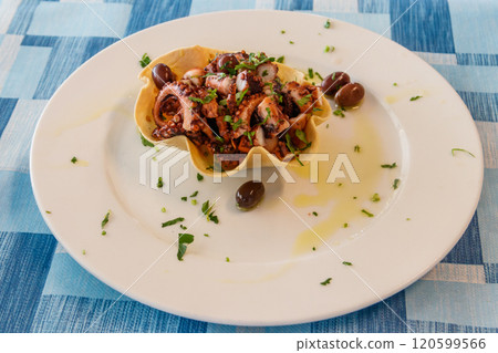 Tasty grilled octopus with potato and olive on a table in restaurant Tasty grilled octopus with potato and olive on a table in restaurant 120599566