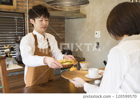 店主將點好的食物遞給大廳工作人員。 店主將點好的食物遞給大廳工作人員。 120599570