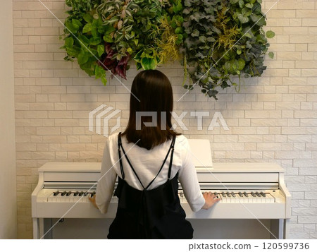 一個女人在房間裡彈電子鋼琴 一個女人在房間裡彈電子鋼琴 120599736