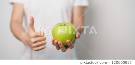 woman hand hold green Apple, happy female fitness choose fruit is Healthy food. Dieting control, Weight loss, Obesity, eating lifestyle and nutrition concepts 120600935