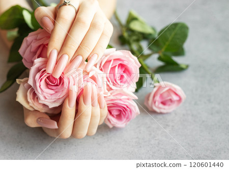 Woman showing pink manicure and diamond ring holding bouquet of roses 120601440