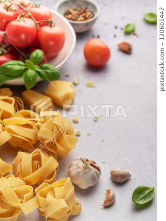 Italian pasta tagliatelle nest with tomatoes, parmesan and garlic on grey background 120601447