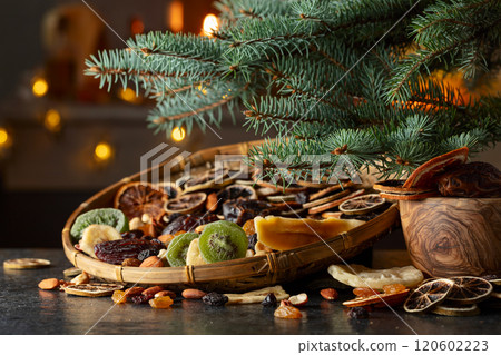 Dried tropical fruits and Christmas tree on a kitchen table. Dried tropical fruits and Christmas tree on a kitchen table. 120602223