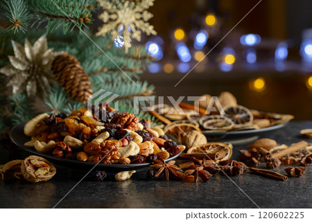 Christmas spices, various nuts, raisins, and dry citrus slices on a kitchen table. Christmas spices, various nuts, raisins, and dry citrus slices on a kitchen table. 120602225