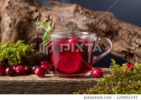 Hot drink with cranberries, lime, and rosemary on a old wooden board. Hot drink with cranberries, lime, and rosemary on a old wooden board. 120602243
