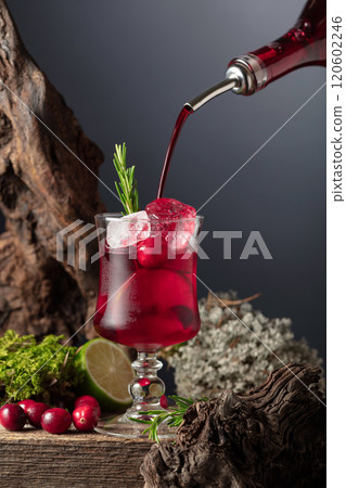 Cranberry cocktail with ice, lime, and rosemary on a old wooden board. Cranberry cocktail with ice, lime, and rosemary on a old wooden board. 120602246