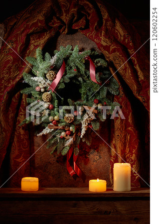 Christmas wreath and burning candles on a vintage background. Christmas wreath and burning candles on a vintage background. 120602254