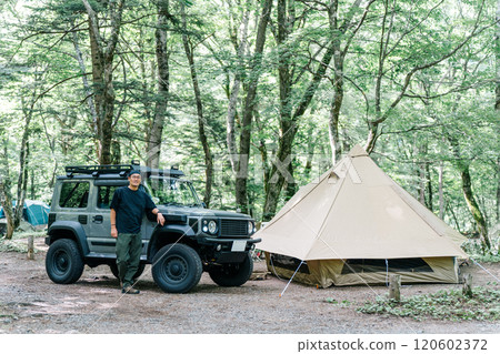 Male camper standing in front of his car (car, RV, SUV) at an auto campsite 120602372