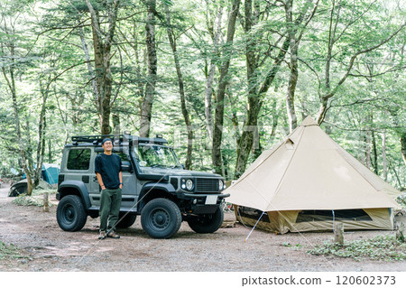 Male camper standing in front of his car (car, RV, SUV) at an auto campsite 120602373