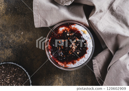 Close up of chia pudding with yogurt and blackcurrant jam in a glass on the table top view 120602909