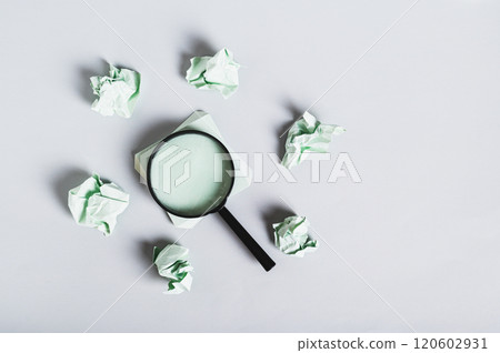 Burnout breaks concept. Magnifier among the papers for writing on the desk top view Burnout breaks concept. Magnifier among the papers for writing on the desk top view 120602931