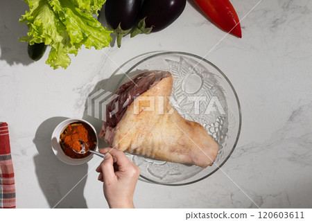 A person is carefully dipping a delicious piece of meat into a bowl of sauce A person is carefully dipping a delicious piece of meat into a bowl of sauce 120603611