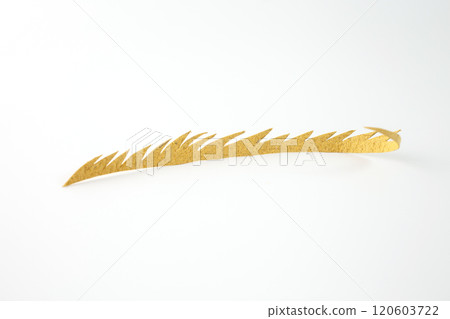 yellow paper cut into specific shape, one long, curved piece with jagged edges. The background is a plain white surface. part of a craft project, 120603722