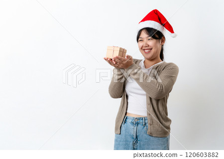A woman wearing a red santa hat is holding a small wooden box 120603882