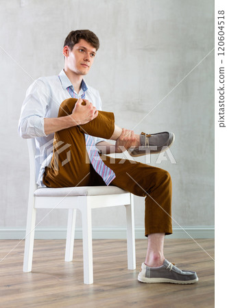 Young guy office worker doing exercises on chair 120604518