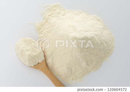 An overhead view of protein powder served on a wooden spoon on a white background An overhead view of protein powder served on a wooden spoon on a white background 120604572