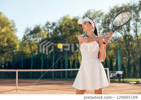 Beautiful female tennis player having a workout on the tennis court 120605199