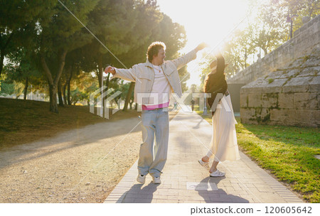 A Joyful Couple Enjoying a Blissful Sunlit Stroll Together in the Beautiful Outdoors of Nature A Joyful Couple Enjoying a Blissful Sunlit Stroll Together in the Beautiful Outdoors of Nature 120605642