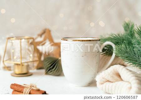 Cup of hot cocoa or coffee with fir tree, candle, wooden star and warm cozy sweater. Christmas greeting card, lights background. Xmas holiday eco nature decorations. Zero waste 120606587