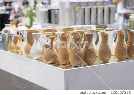 Beige vases are sold in shop. Jars for bouquets of flowers. Sale of items for decorating premises. 120607858