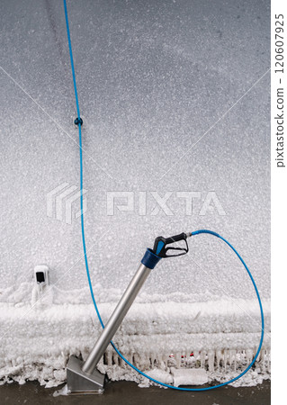 A close-up of industrial-grade snow-cleaning equipment in use. A functional, wintry scene showcasing technical precision in icy conditions. 120607925