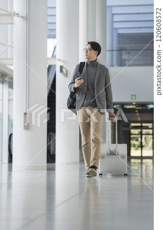 一名 40 多歲男子背著隨身行李行走 120608572