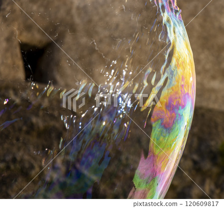 Colourful photo of the exact moment a giant bubble pops 120609817