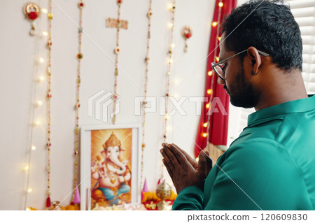 Praying to Ganesha at Home with Decorated Altar 120609830