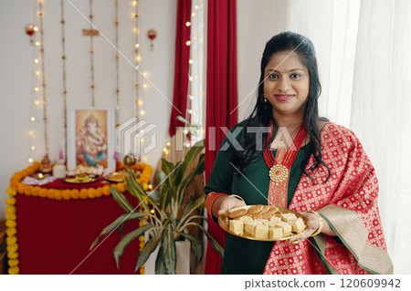 Holding a Plate of Traditional Indian Sweets Smiling at Camera 120609942