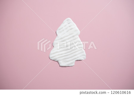 white cream shaped like a Christmas tree on pink background. Holiday makeup and body care white cream shaped like a Christmas tree on pink background. Holiday makeup and body care 120610616