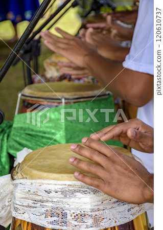 Hands playing several atabaque drums 120610737